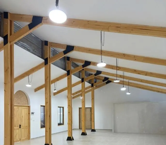 Iluminación interior instalada en un salón con vigas de madera
