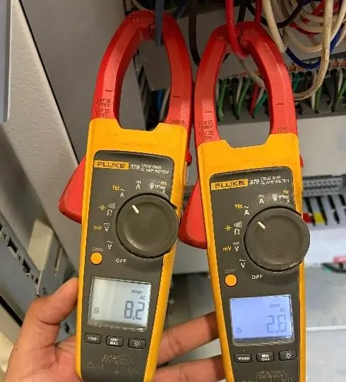 Medición de corriente con dos pinzas amperimétricas junto a un tablero